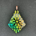 Etched peach, gold, and teal on black diamond-shaped dichroic glass pendant.